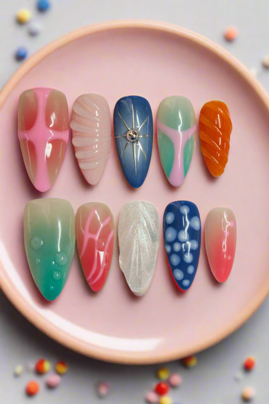 Set of colorful nail art designs in a clear case on a marble surface