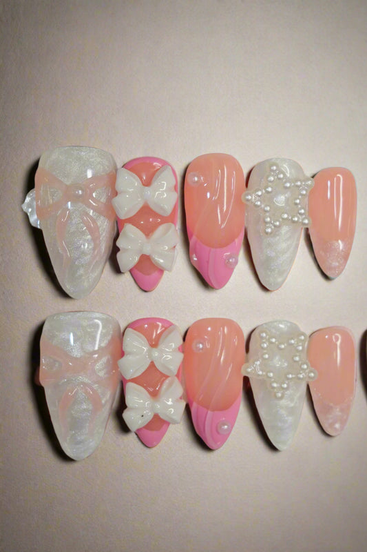 Set of decorative false nails with bows and rhinestones on a white background